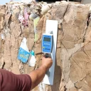 کارشناس کنترل کیفیت در حال اندازه‌گیری رطوبت ضایعات کارتن با دستگاه، قبل از ورود به خط تولید